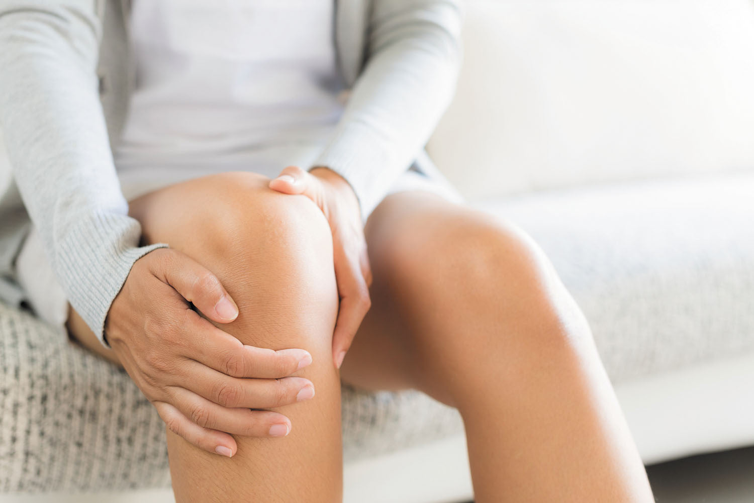 Person holding their knee, possibly indicating discomfort or injury